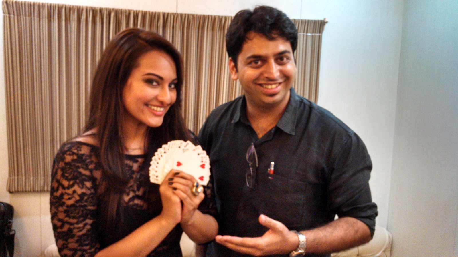 Magic Mangesh with Sonakshi Sinha, who is holding a fan of cards